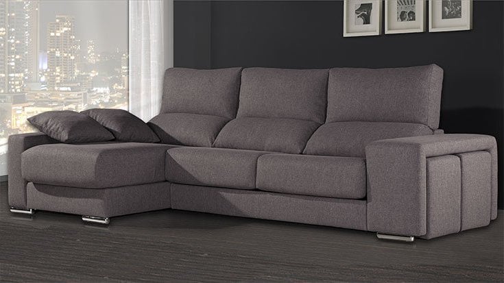 Sofá chaise longue gris moderno con dos pufs integrados en el brazo y patas cromadas en un salón contemporáneo