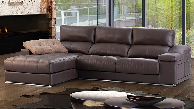 Sofá chaise longue de cuero marrón oscuro con cabezales ajustables en un salón moderno con suelo de madera