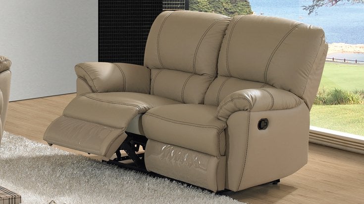 Sofá reclinable de dos plazas en piel beige con costuras decorativas y mecanismo manual en sala de estar moderna